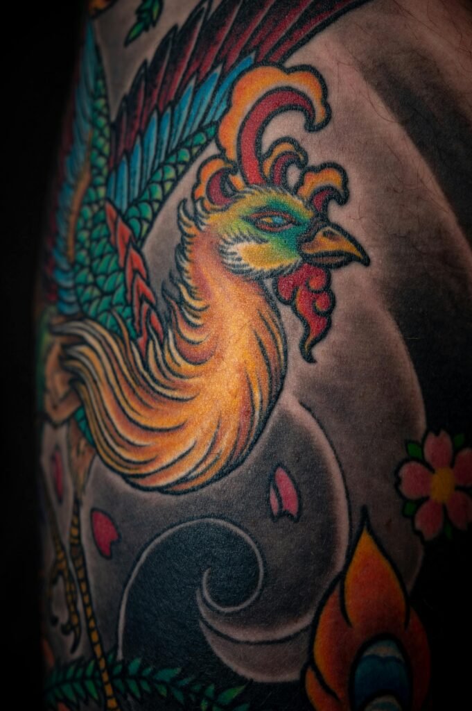 Close-up of a vibrant phoenix tattoo showcasing creative artwork on skin.