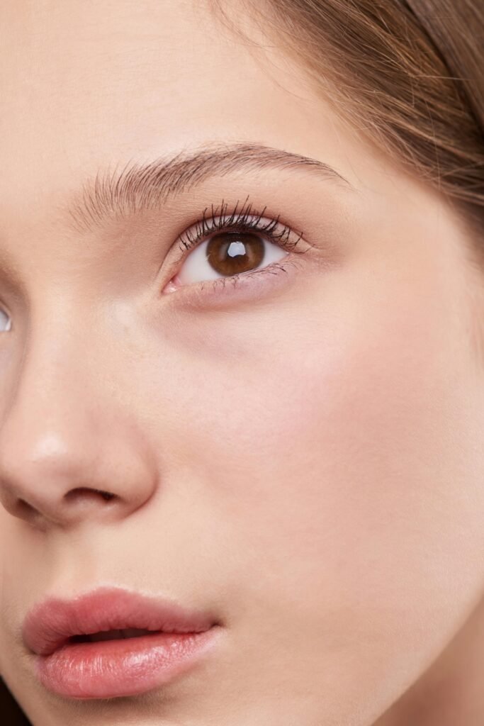 Close-up portrait capturing the natural beauty and smooth skin of a young woman.