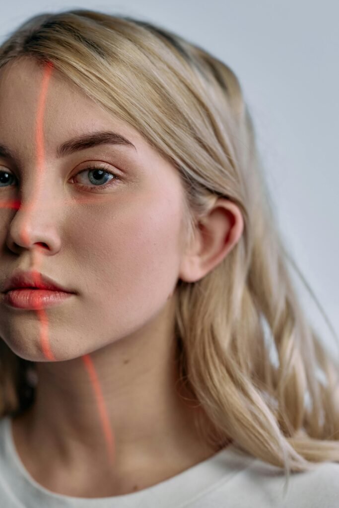 Close-up portrait of woman with laser scanning lines, symbolizing advanced technology in facial recognition.